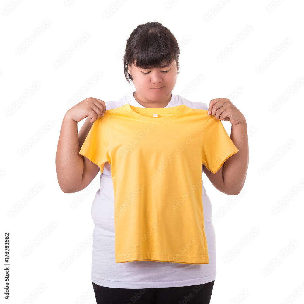 Fat asian woman trying to wear small size of yellow t-shirt isolated on white. Fat and Healthcare concept Fat asian woman trying to wear small size of yellow t-shirt isolated on white. Fat and Healthcare concept