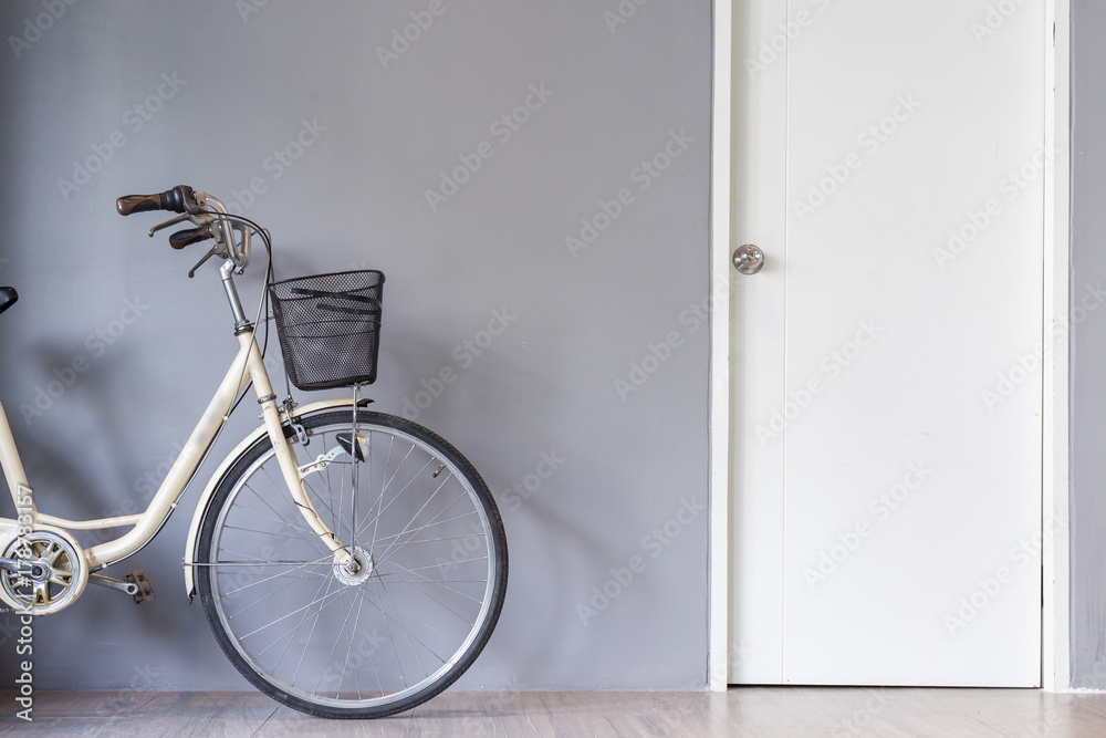 Bicycle parking near the grey wall and white door Bicycle parking near the grey wall and white door