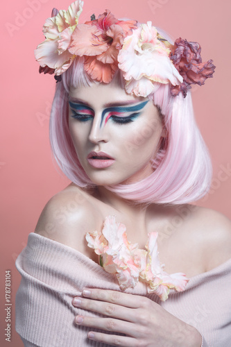 Fototapeta Naklejka Na Ścianę i Meble -  Fashion beauty portrait of a beautiful girl with pink hair, creative make-up and a wreath of gladiolus on her head.