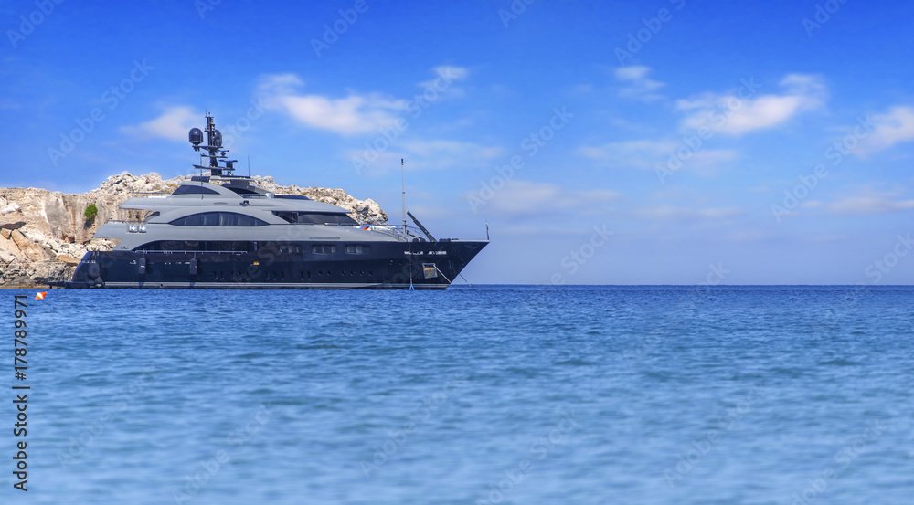 Big luxury beautiful yacht docked at summer sea but ready to travel to tropical beautiful water