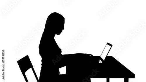 Woman uses the laptop at the table then stands up and leaves silhouette