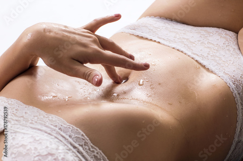 Sexy woman is lying and touching her belly.