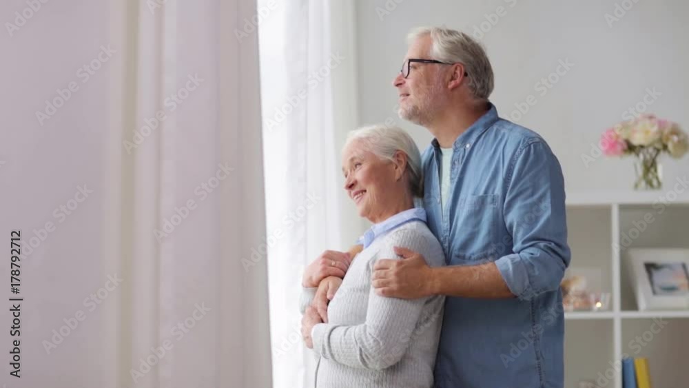 happy senior couple looking through window at home happy senior couple looking through window at home