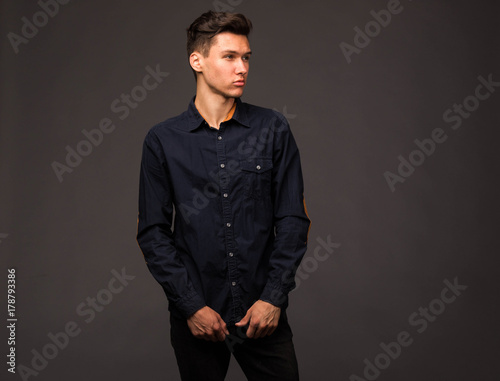 Young confident man portrait of a businessman on a black background. Ideal for banners, registration forms, presentation, landings, presenting concept.