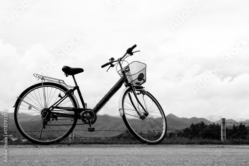 A bicycle stands at near of a runway and mountain. © kannika2012