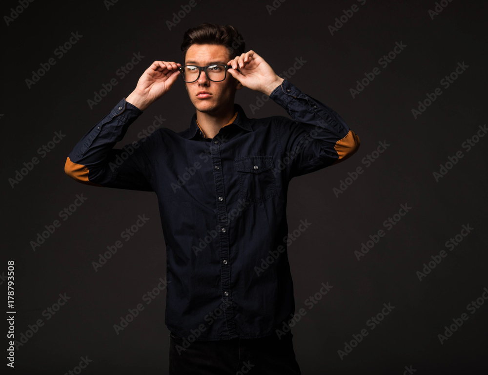 Young pensive man portrait of a confident businessman on a black background. Ideal for banners, registration forms, presentation, landings, presenting concept.