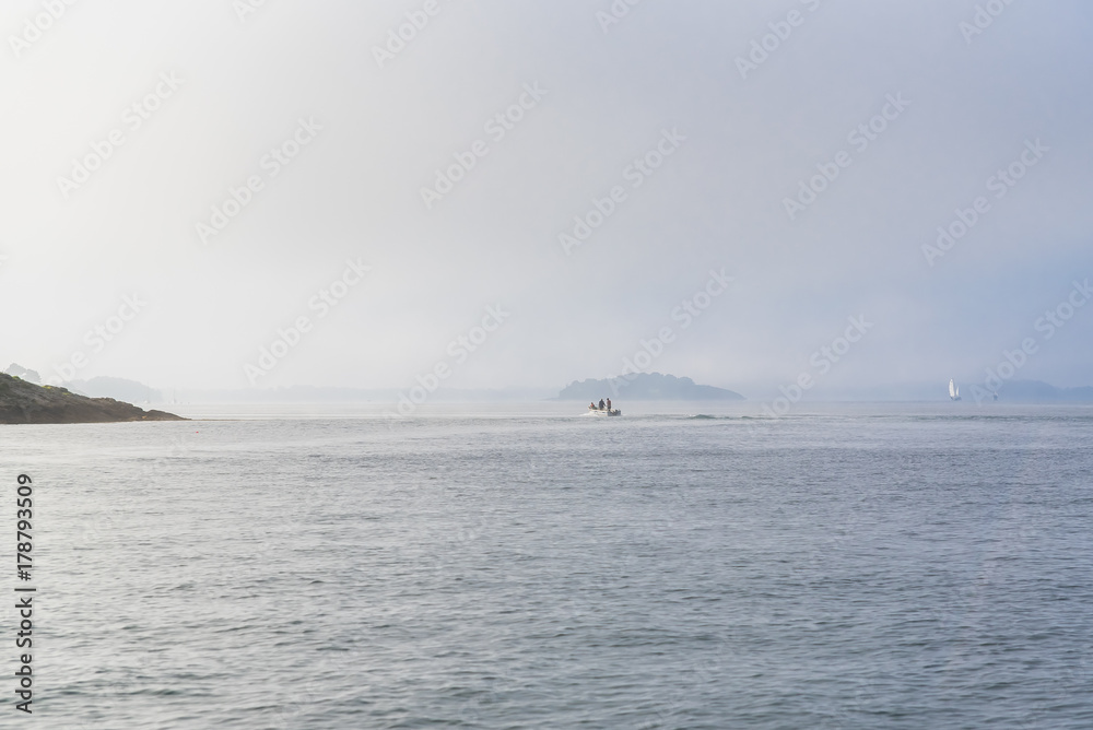 Beautiful panorama of the Morbihan gulf, view off season, boat in the mist in the morning
