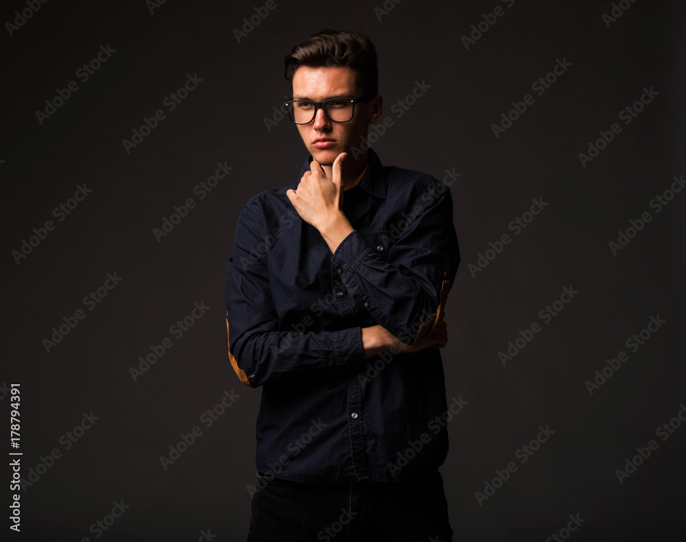 Young confident man portrait of a businessman showing by hands on a black background. Ideal for banners, registration forms, presentation, landings, presenting concept. Young confident man portrait of a businessman showing by hands on a black background. Ideal for banners, registration forms, presentation, landings, presenting concept.