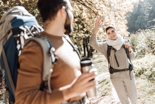 Cheerful girl waving good bye to her boyfriend