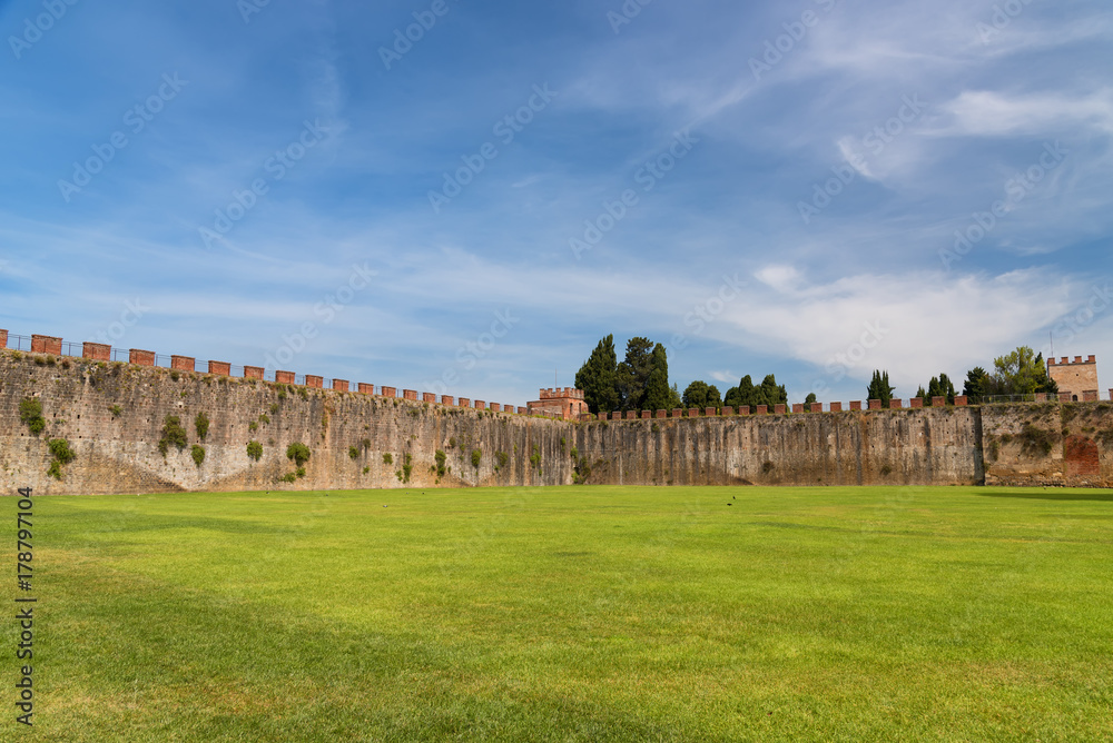 Field of Miracles (Campo dei Miracoli) next to the walls behind the Baptistery of St. John (Battistero) in Pisa, Tuscany, Italy Field of Miracles (Campo dei Miracoli) next to the walls behind the Baptistery of St. John (Battistero) in Pisa, Tuscany, Italy