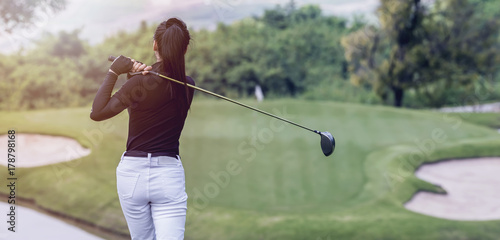 Young women player golf swing shot on course