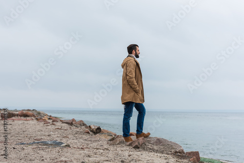 man standing on seashore