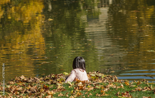 Kind Spielt An Einem See Mit Laub im Herbst