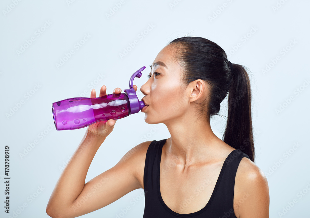 Young sports woman drinks bottled water Young sports woman drinks bottled water
