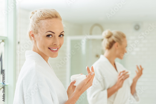 woman in bathrobe applying face cream © LIGHTFIELD STUDIOS