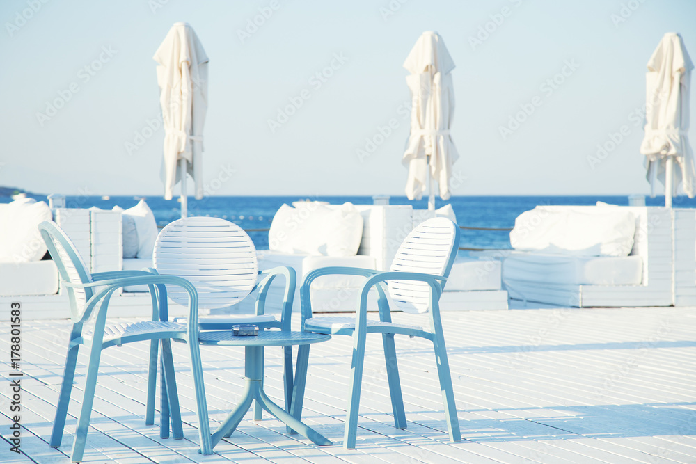 Chairs and table of beach near sea.