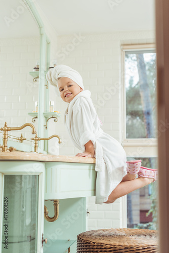 child in bathrobe and towel on head