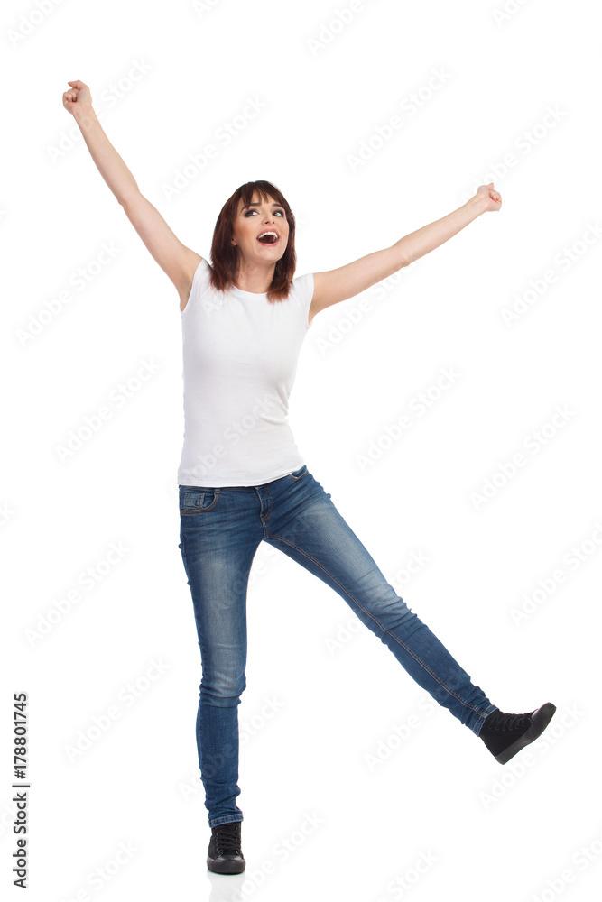 Happy Woman Is Standing On One Leg, Rising Arms And Laughing