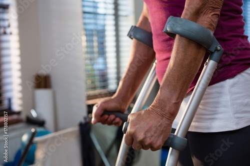 Fototapeta Mid-section of woman with crutches