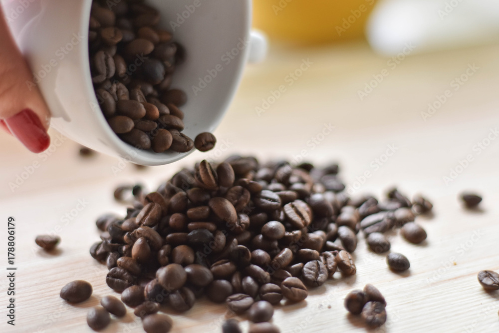 Woman hand holding a cup full of coffee beans Woman hand holding a cup full of coffee beans