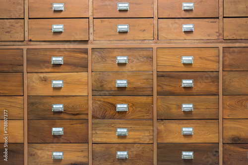 Rows of little drawers with white empty tags in an old furniture module photo