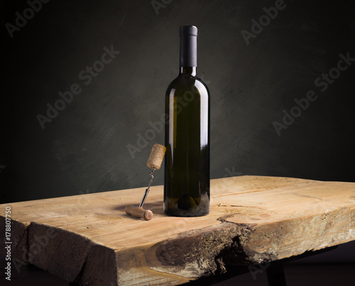 red wine bottle and wine glass on wodden barrel photo