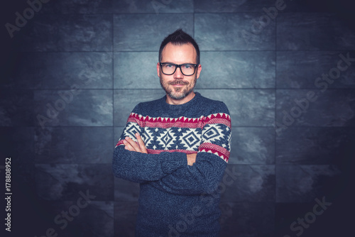 Men wearing blue sweater and eyeglasses posing