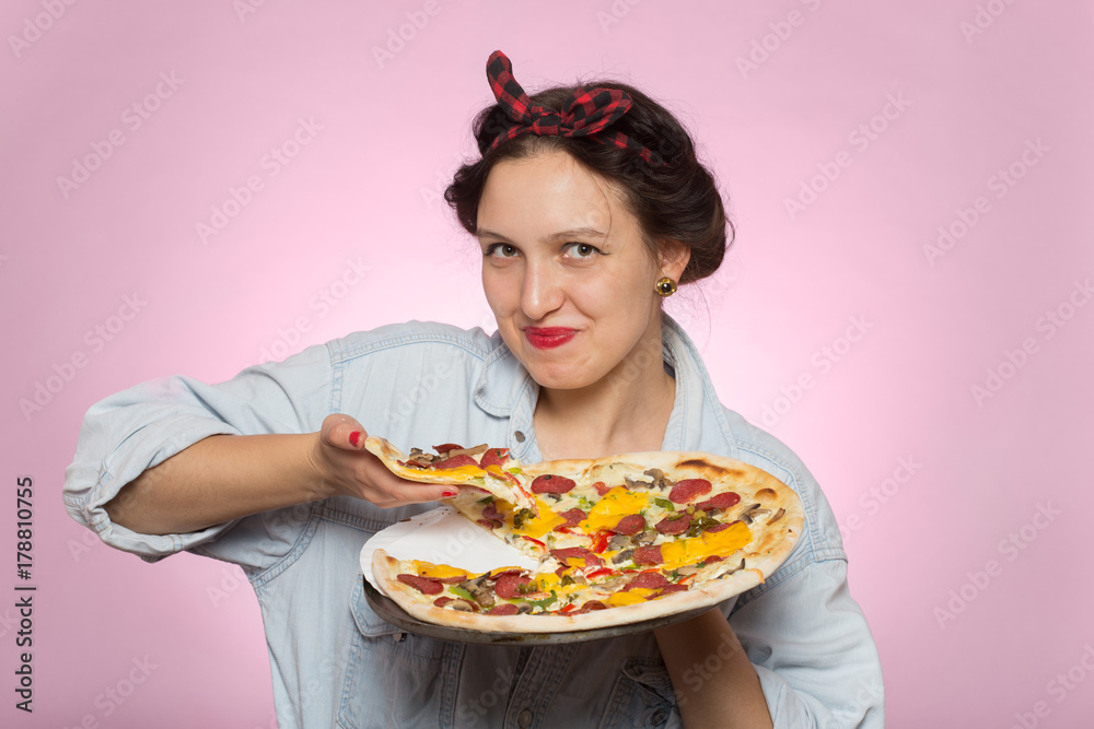 happy woman presents pizza on pink background