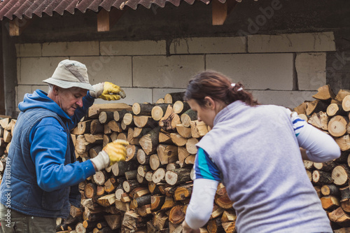 Obraz na płótnie Daughter and father making a woodpile for winter. w salonie