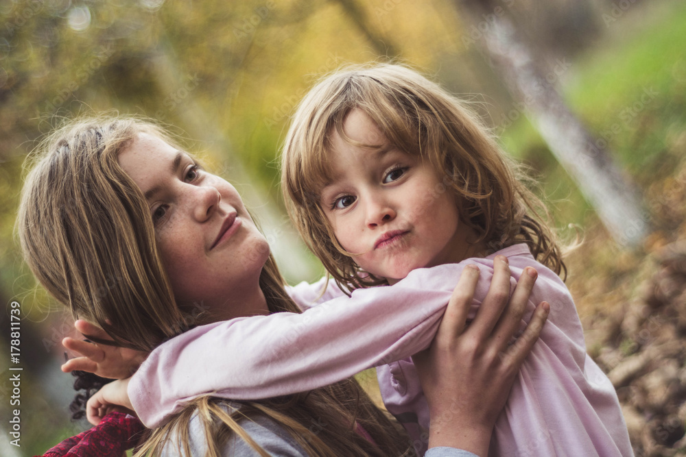 Fototapeta premium Young sisters playing together in the garden.