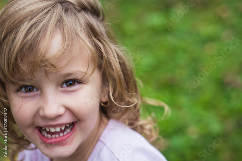 Young, blonde girl joyfully smiling. Close-up. Fototapeta