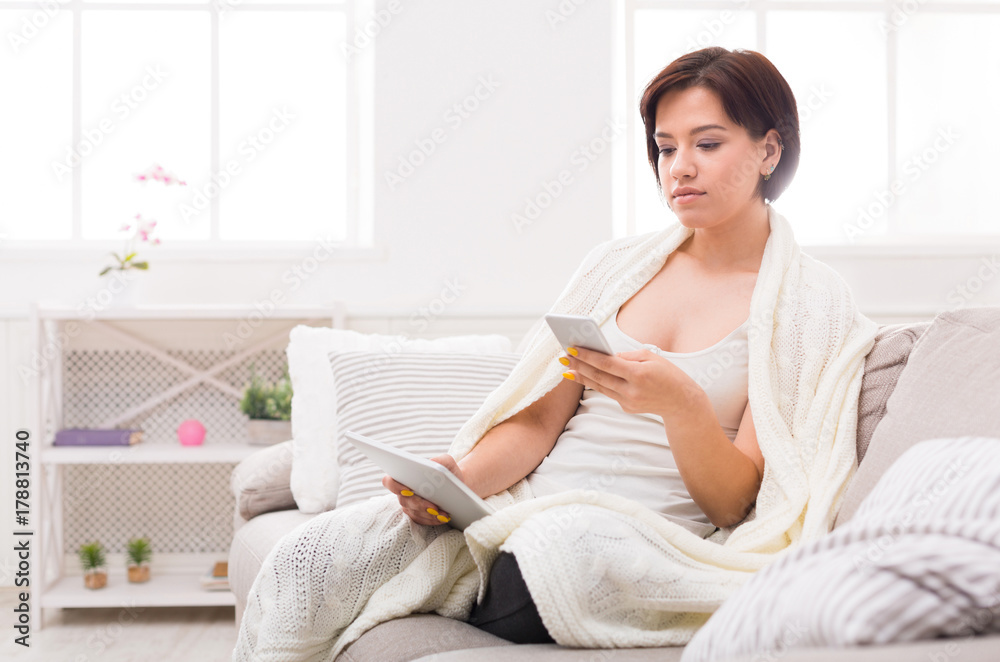 Enjoying free time at home. Pensive girl with tablet and phone Enjoying free time at home. Pensive girl with tablet and phone