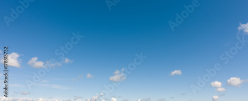 Light blue sky with clouds. Panorama white clouds flying against blue sky.