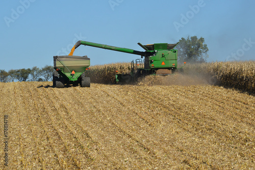 Canvas-taulu Combine harvesting corn and unloading to trailer
