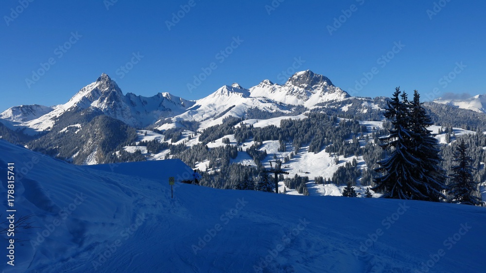View from the Hohe Wispile ski area, Gstaad. Snow covered mountains Gummfluh and Videmanette.