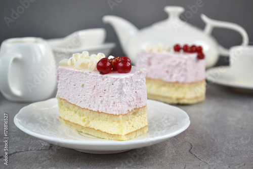 ruit Mousse Cake, decorated fresh red berries and grated white chocolate, in a white plate. Minimal baking and a light, chilled dessert with fresh fruit flavors. 