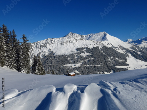Winter landscape near Gstaad, Switzerland. Snow covered mountains Gifer and Lauenenhorn. 