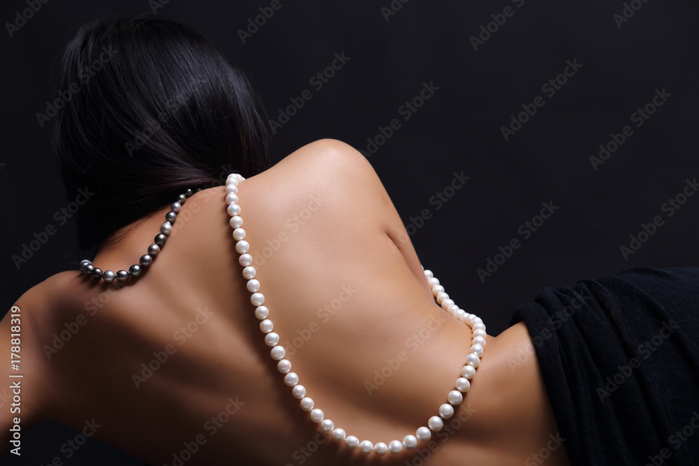 Portrait of beautiful nude long straight black hair woman with pearl necklace