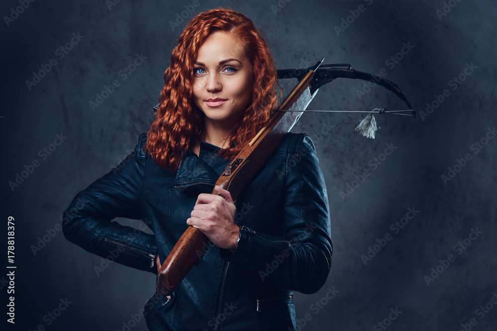 Redhead female  holds crossbow.