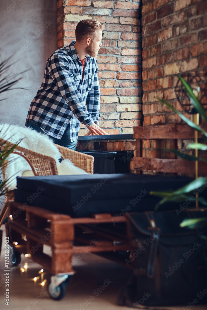 A blond bearded hipster male dressed in a jeans and fleece shirt A blond bearded hipster male dressed in a jeans and fleece shirt