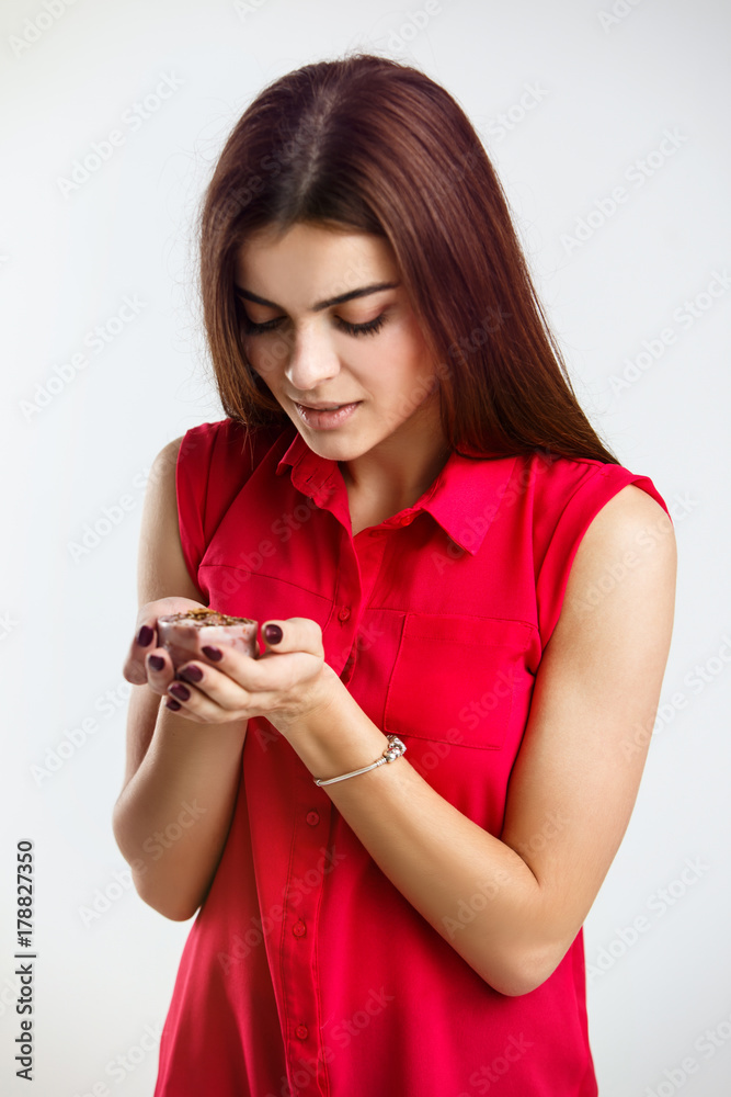 Woman wears red shirt holds decorative aromatic soap on white background Woman wears red shirt holds decorative aromatic soap on white background