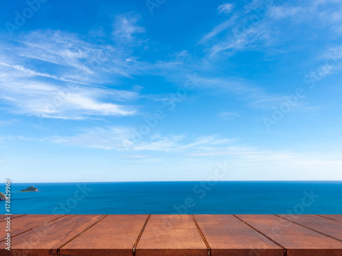 Empty wooden table on blue sky with seascape background