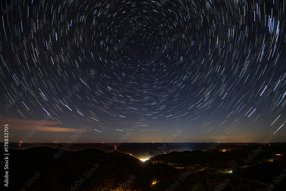 Fototapeta premium Star Trails Over Rural Town