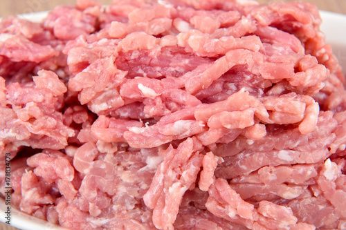 ground pork in a white plate on wooden table