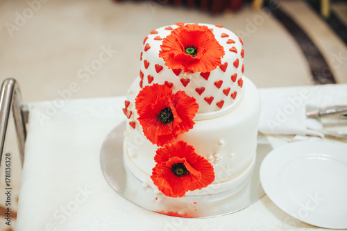 beautiful wedding cake with red poppies and hearts photo
