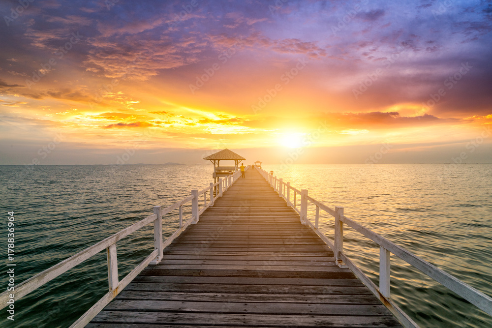 Wooden bridge in the sea at sunset