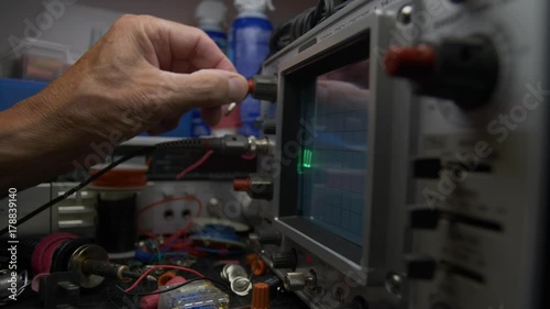 ELECTRICAL DIAGNOTIC EQUIPMENT.  SLOW DOLLY SHOT OF A HAND MAKING ADJUSTMENTS. photo