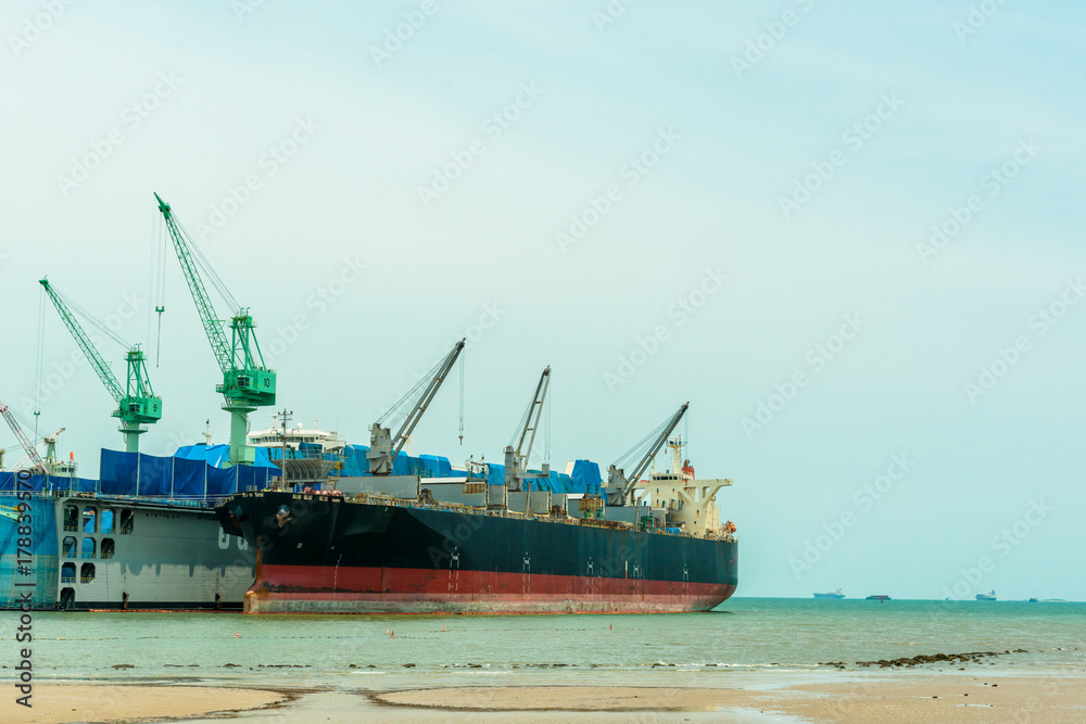 Large ship building site dry dock with cargo ship dock next to it. Large ship building site dry dock with cargo ship dock next to it.