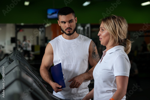 Middle aged woman exercising with fitness coach