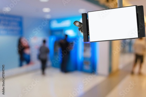 CCTV and LCD TV with white blank screen or billboard with blurred image of people queuing to withdraw money from ATM banking machine at bank, advertising, commercial and marketing concept